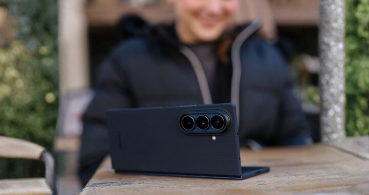 outdoor photo showing the galaxy z fold 8 with aramid fiber case and a girl in black in the background